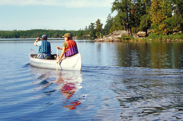 Two people paddle in a canoe.